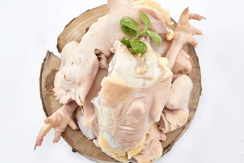 摆放在白色背景上分切好的生鲜鸡腿图片