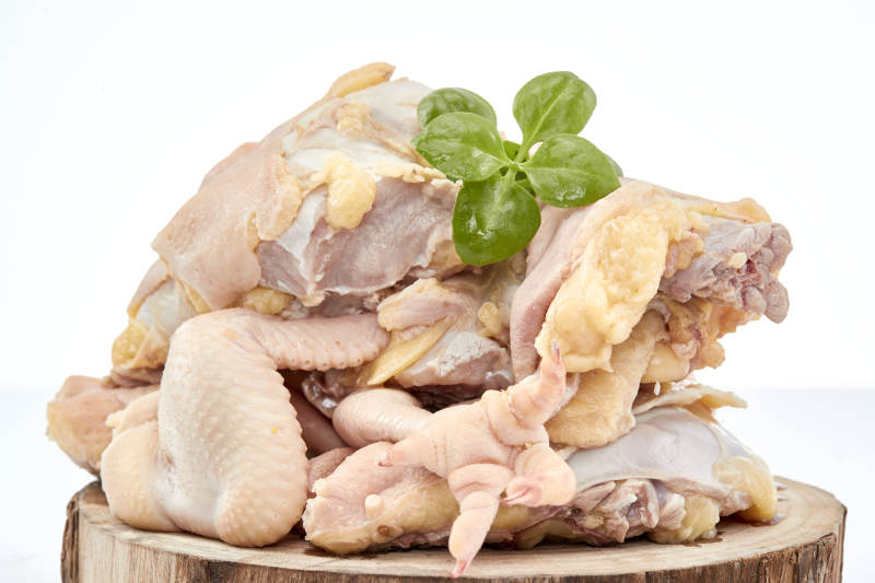 摆放在白色背景上分切好的生鲜鸡腿图片