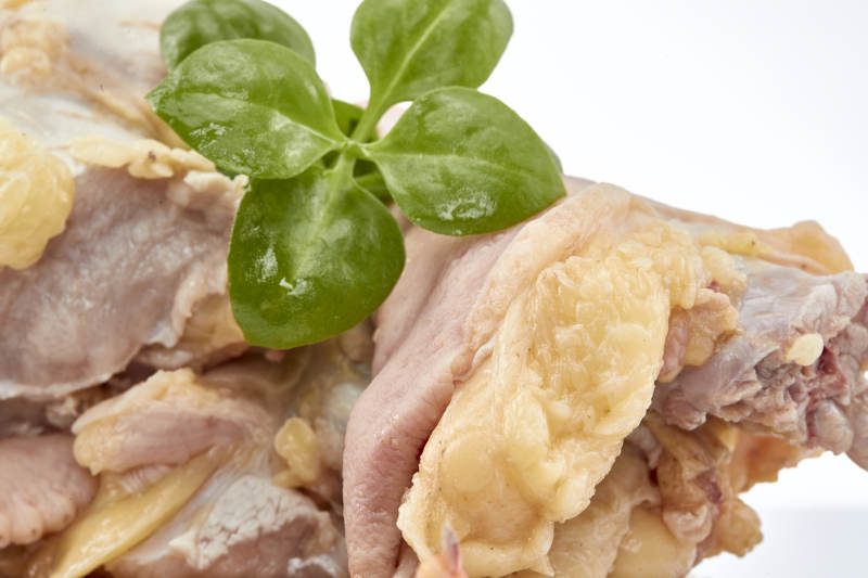 摆放在白色背景上分切好的生鲜鸡腿图片