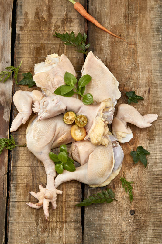 摆放在木板上的分切好的生鲜鸡肉图片