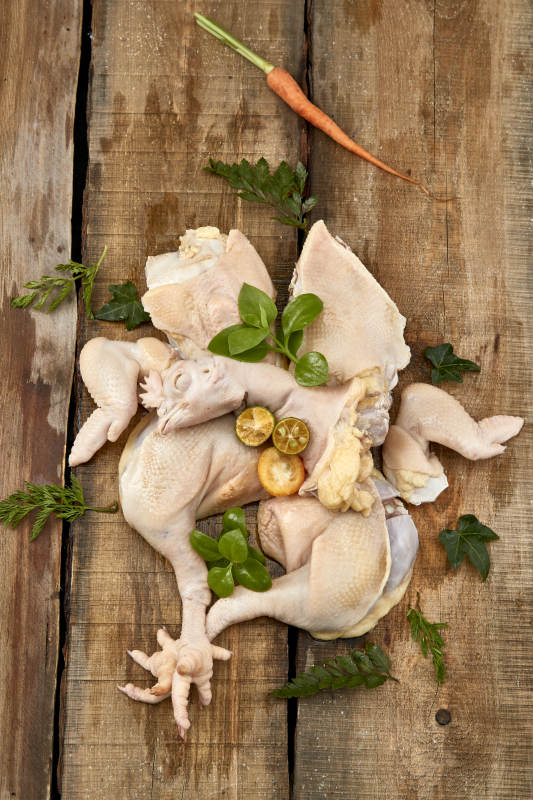 摆放在木板上的分切好的生鲜鸡肉图片