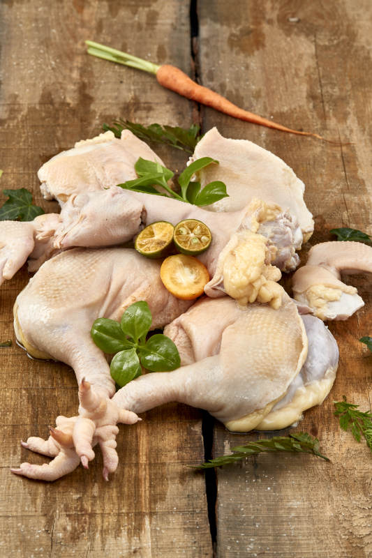 摆放在木板上的分切好的生鲜鸡肉图片