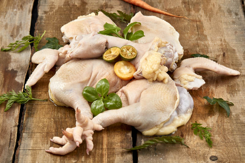 摆放在木板上的分切好的生鲜鸡肉图片