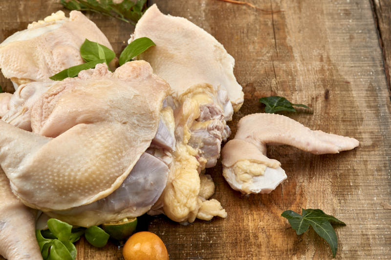 摆放在木板上的分切好的生鲜鸡肉图片