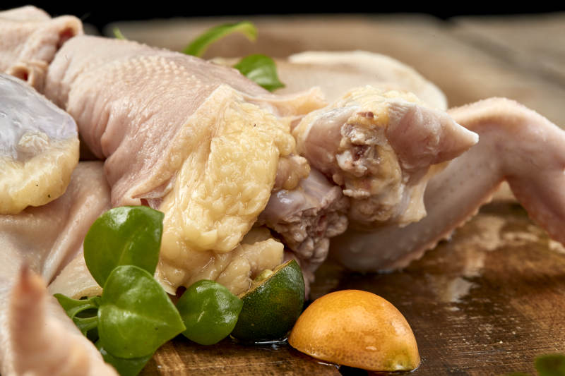 摆放在木板上的分切好的生鲜鸡肉图片