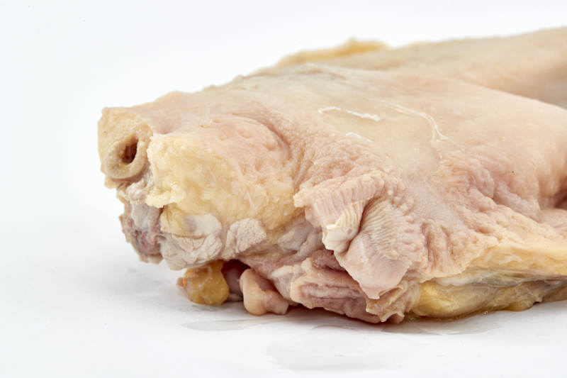 摆放在白色背景上分切好的生鲜鸡腿图片