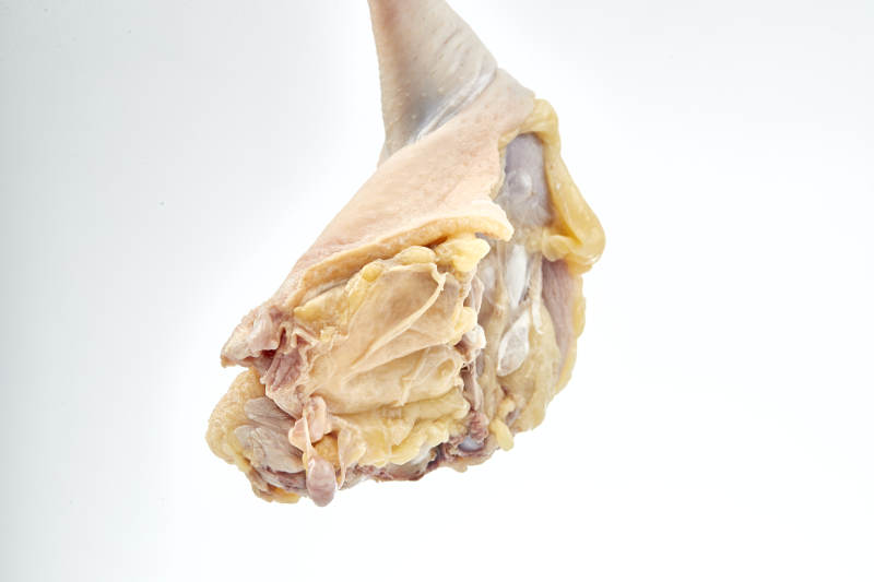 摆放在白色背景上分切好的生鲜鸡腿图片