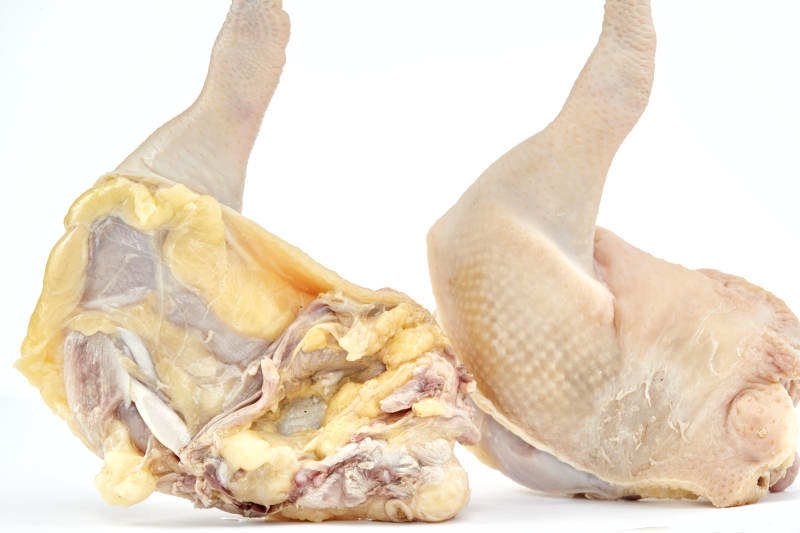 摆放在白色背景上分切好的生鲜鸡腿图片
