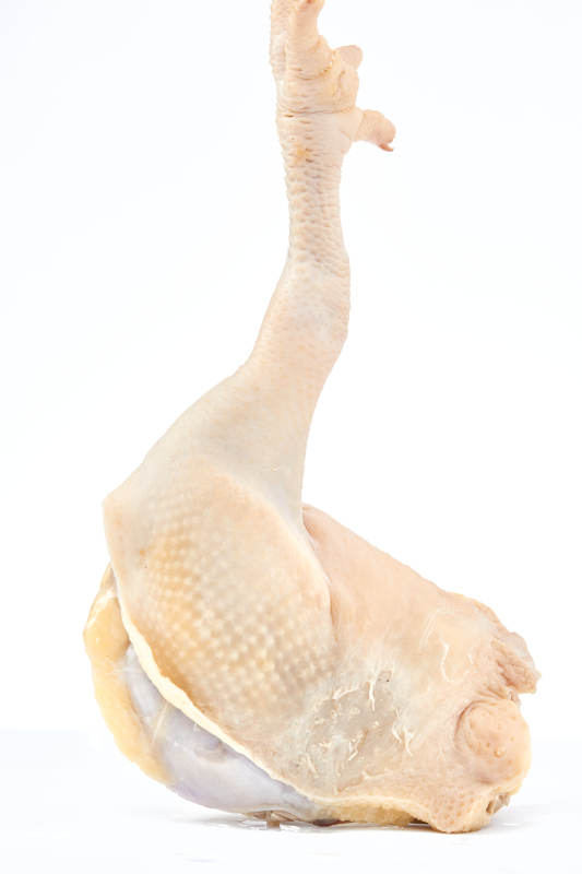 摆放在白色背景上分切好的生鲜鸡腿图片