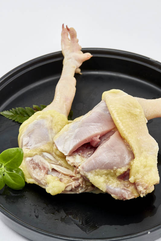 摆放在白色背景上分切好的生鲜鸡腿图片