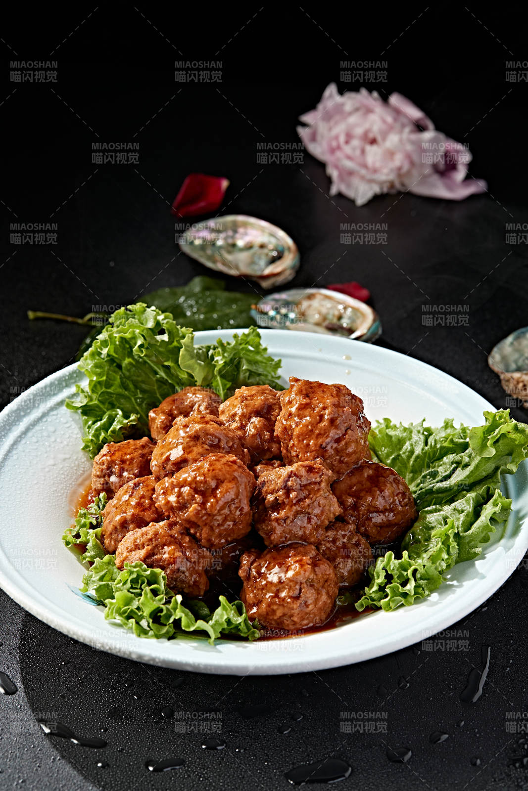 白色瓷盘装的红烧丸子图片