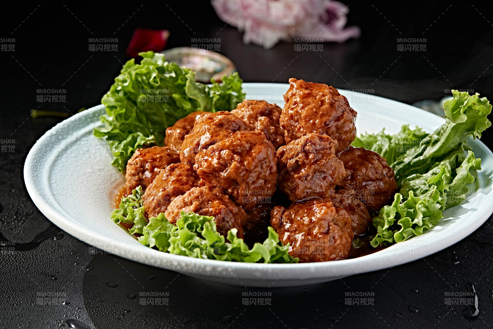 白色瓷盘装的红烧丸子图片