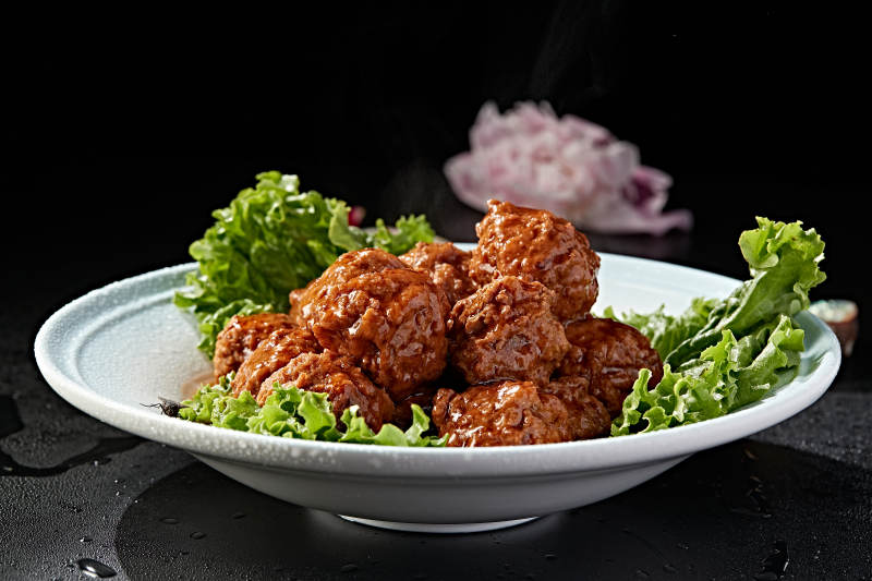 白色瓷盘装的红烧丸子图片