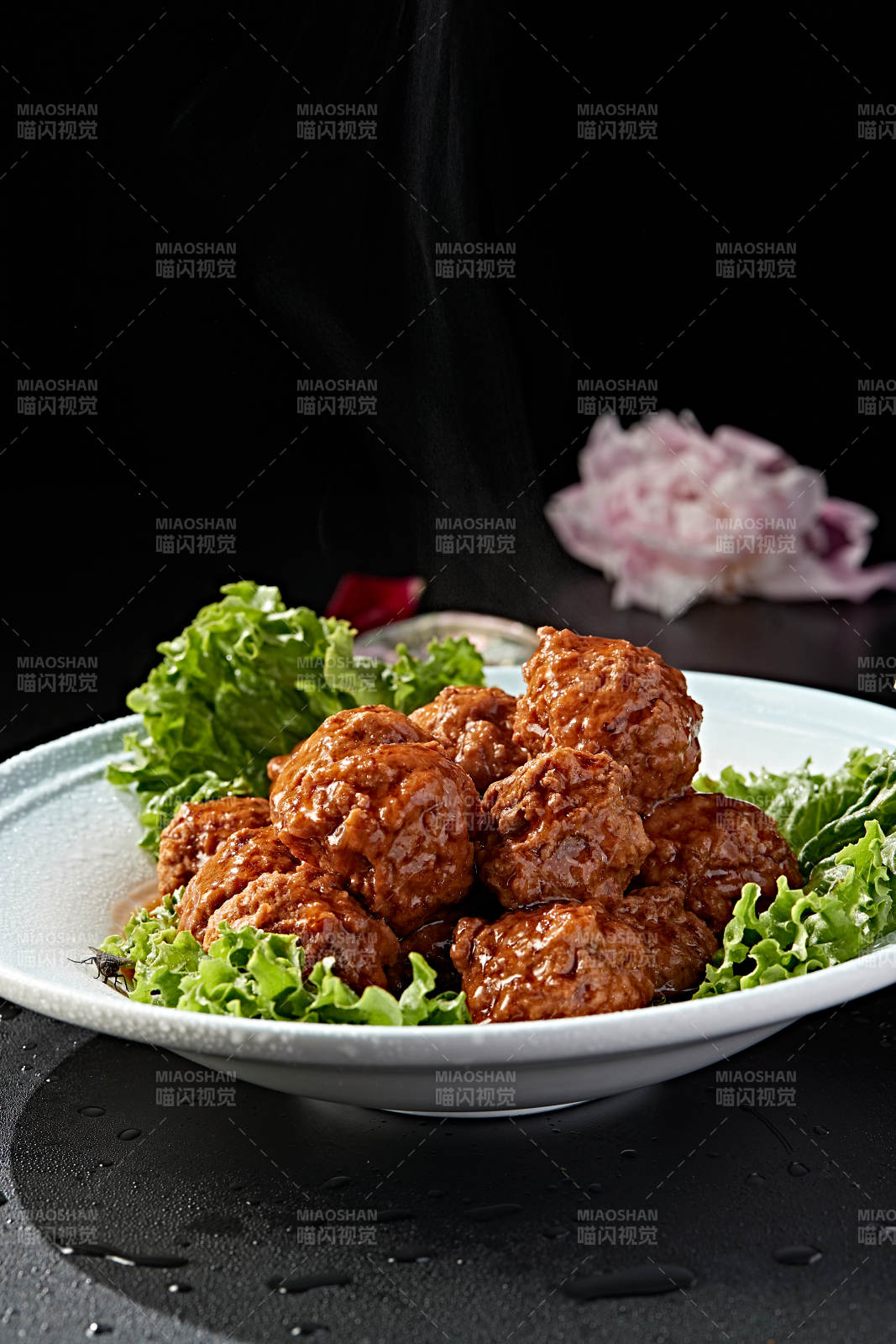 白色瓷盘装的红烧丸子图片