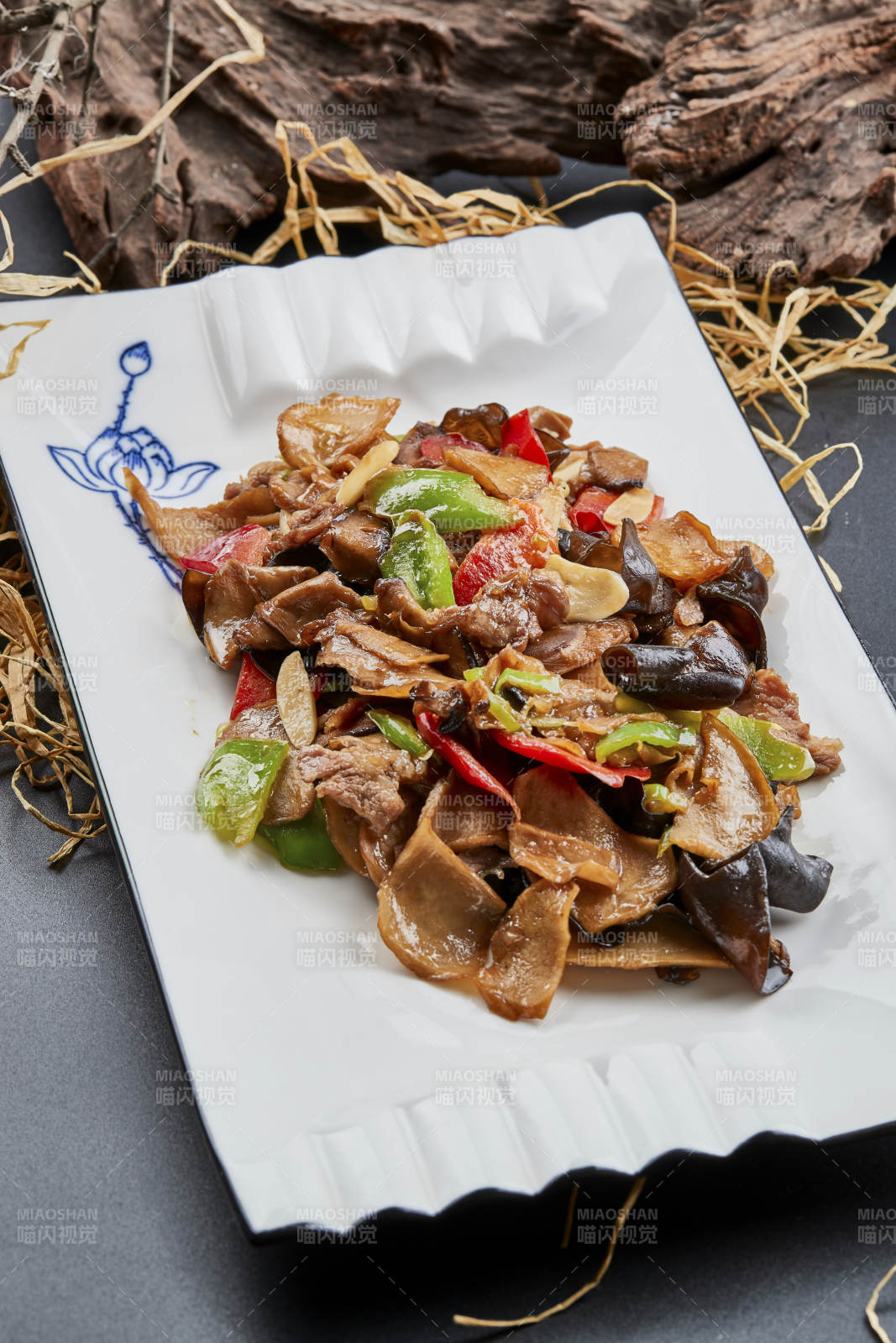 白色瓷盘装的肉炒山珍杂菌图片