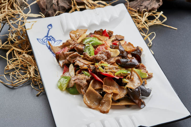 白色瓷盘装的肉炒山珍杂菌图片