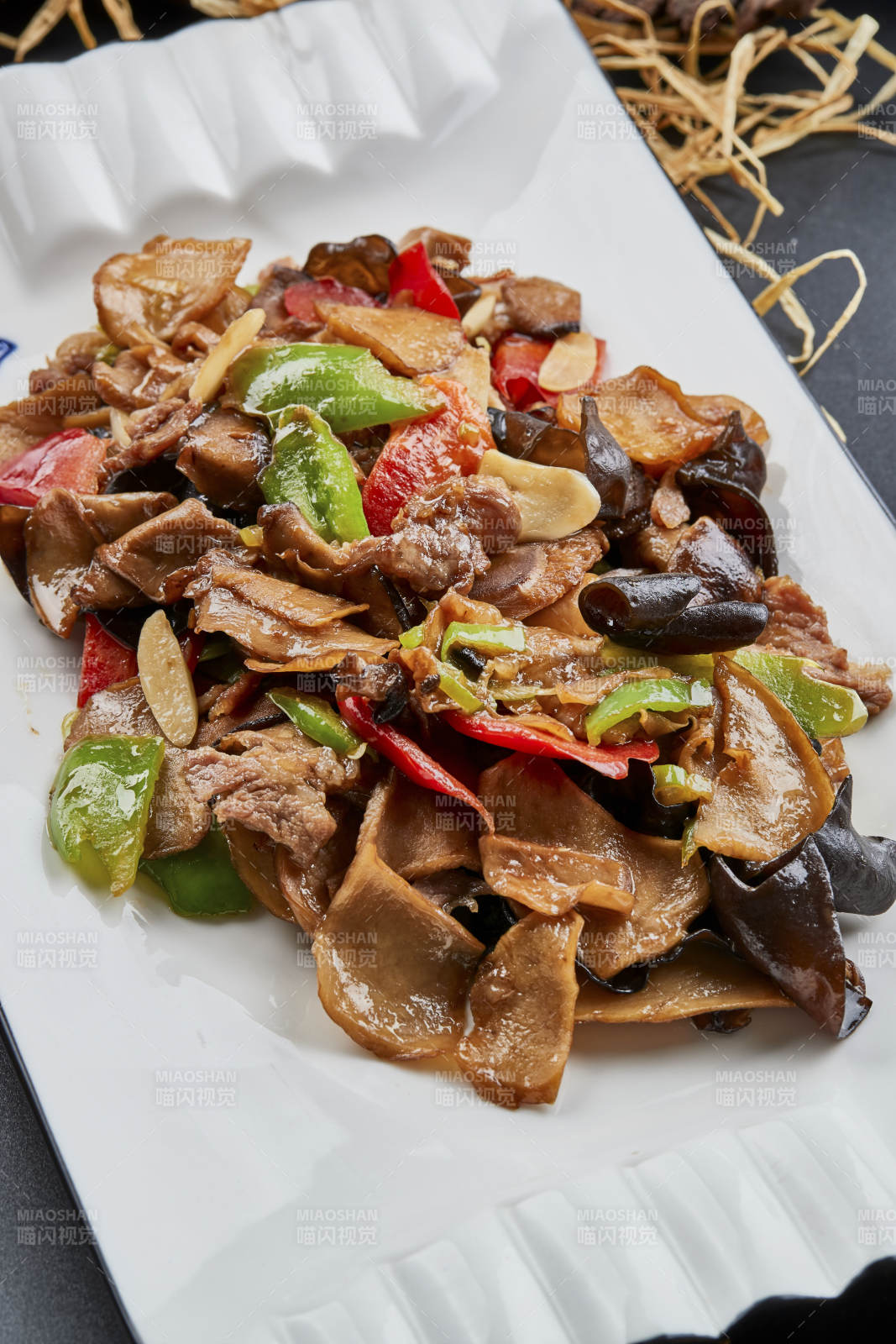 白色瓷盘装的肉炒山珍杂菌图片