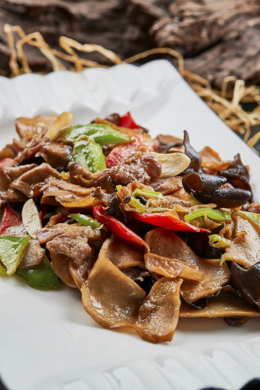 白色瓷盘装的肉炒山珍杂菌图片