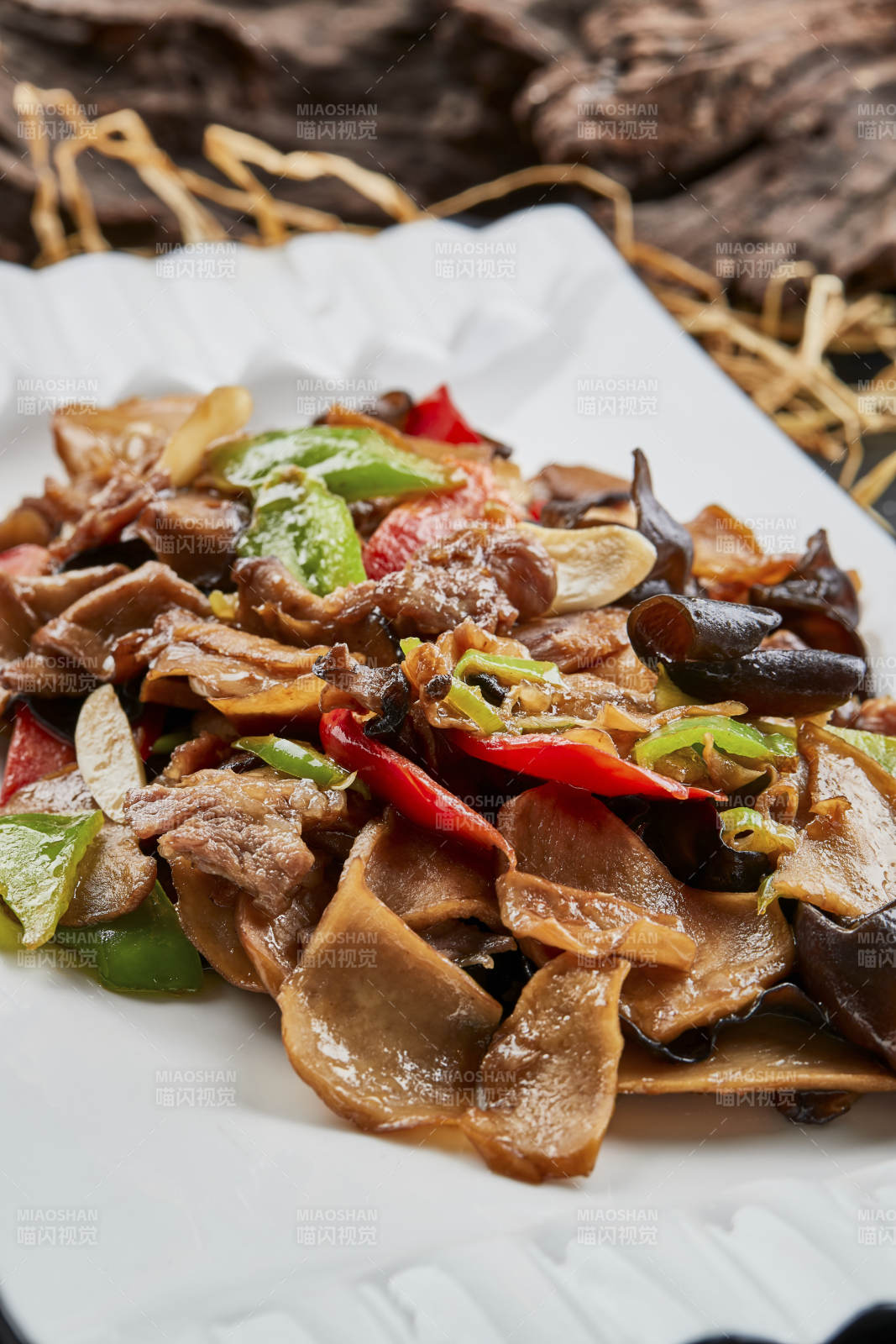 白色瓷盘装的肉炒山珍杂菌图片