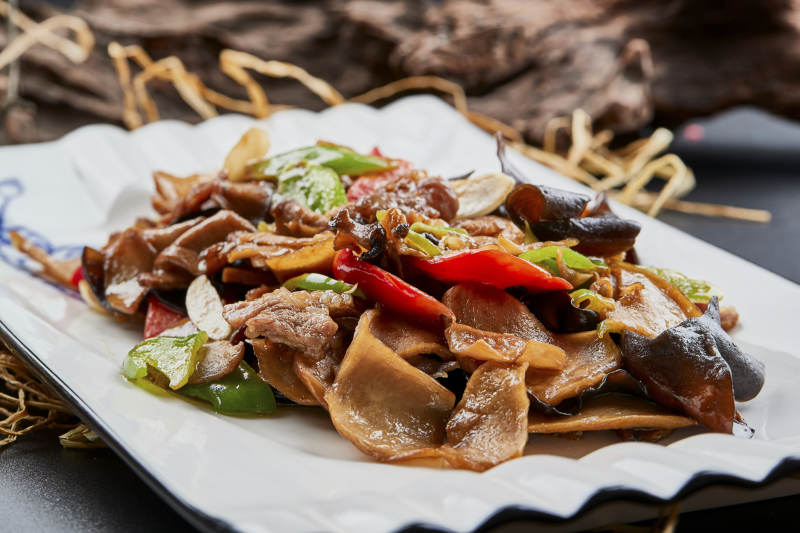 白色瓷盘装的肉炒山珍杂菌图片