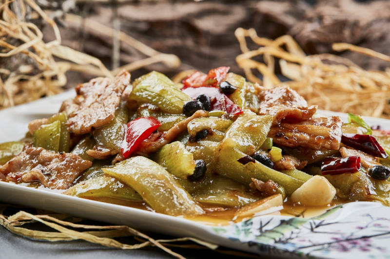 彩绘瓷盘装的猪腹肉炒丝瓜图片