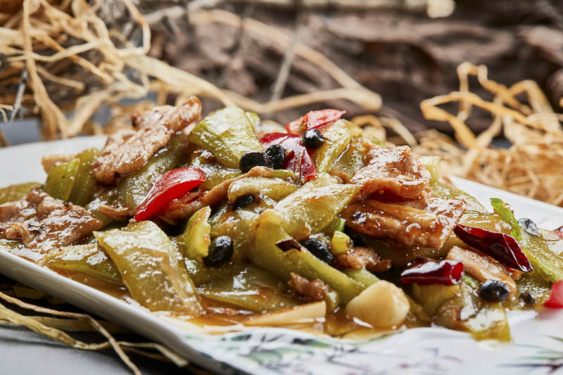 彩绘瓷盘装的猪腹肉炒丝瓜图片