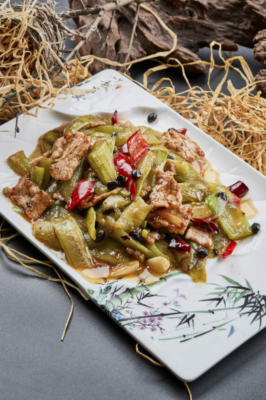 彩绘瓷盘装的猪腹肉炒丝瓜图片