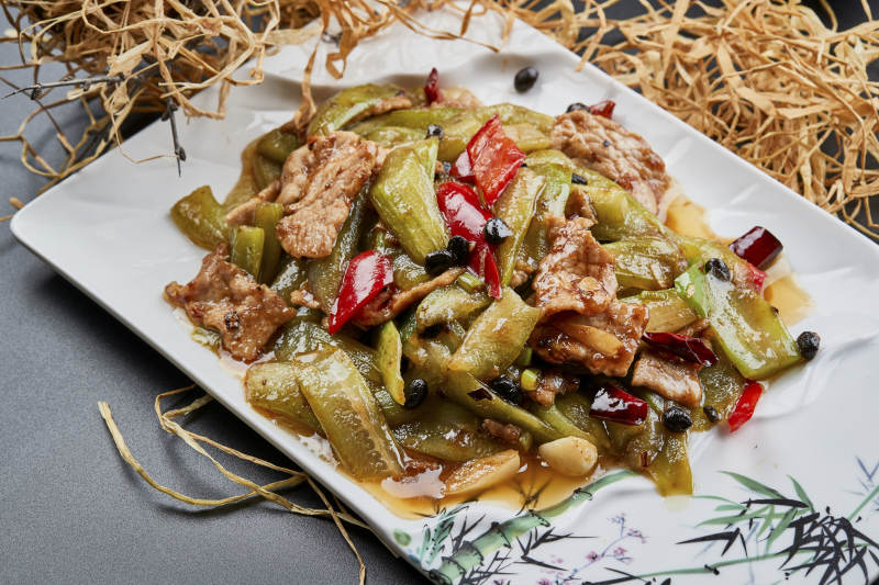 彩绘瓷盘装的猪腹肉炒丝瓜图片