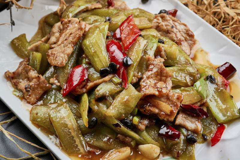 彩绘瓷盘装的猪腹肉炒丝瓜图片