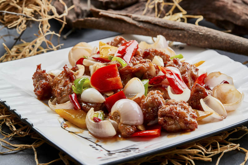 白色瓷盘装的彩椒洋葱猪小排图片