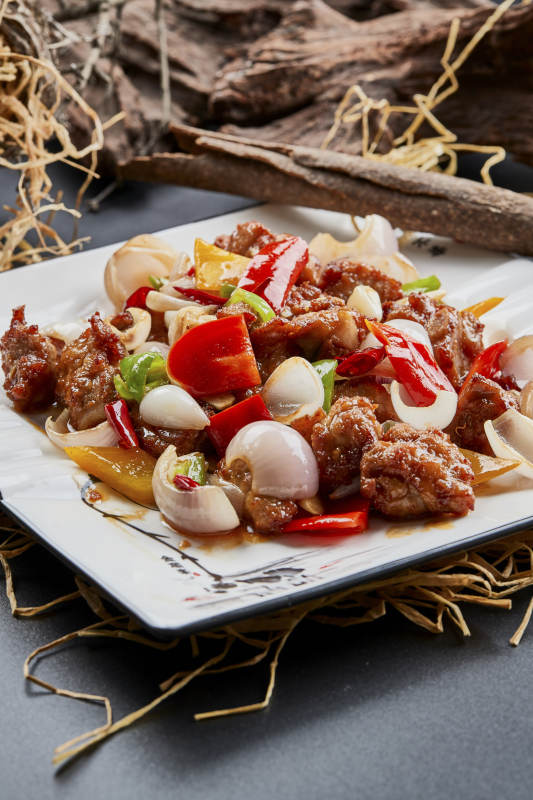 白色瓷盘装的彩椒洋葱猪小排图片