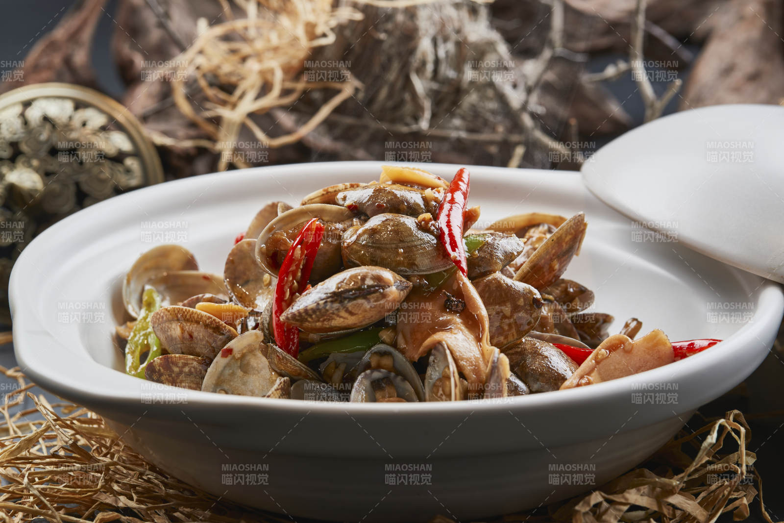 白色砂锅装的辣椒煲花蛤图片