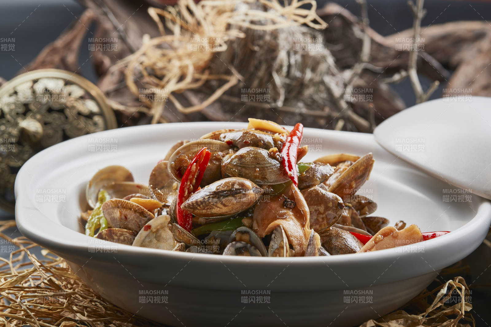 白色砂锅装的辣椒煲花蛤图片