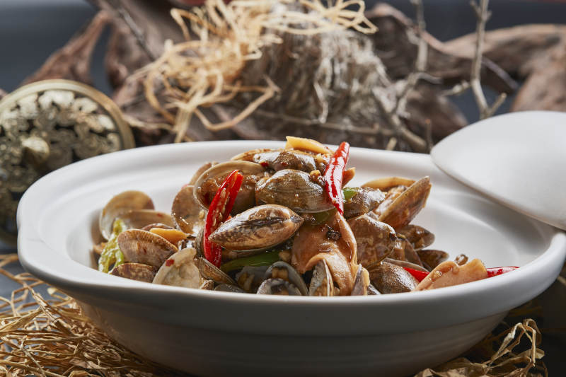 白色砂锅装的辣椒煲花蛤图片