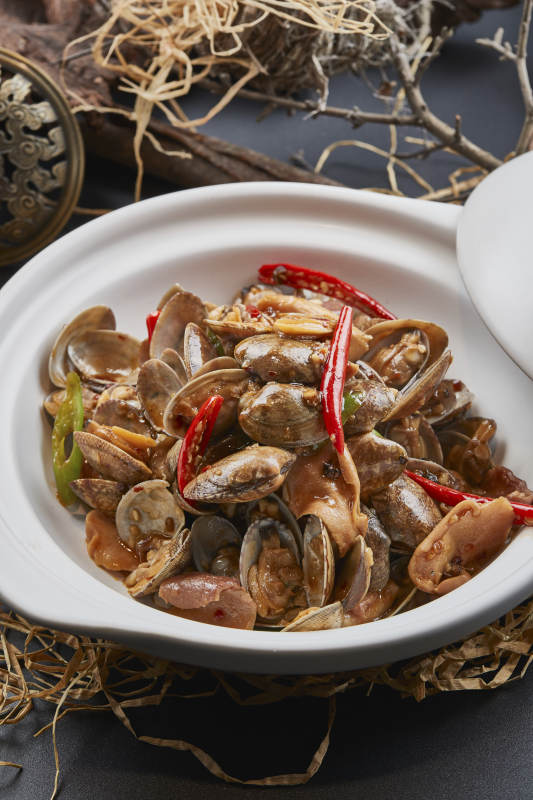 白色砂锅装的辣椒煲花蛤图片