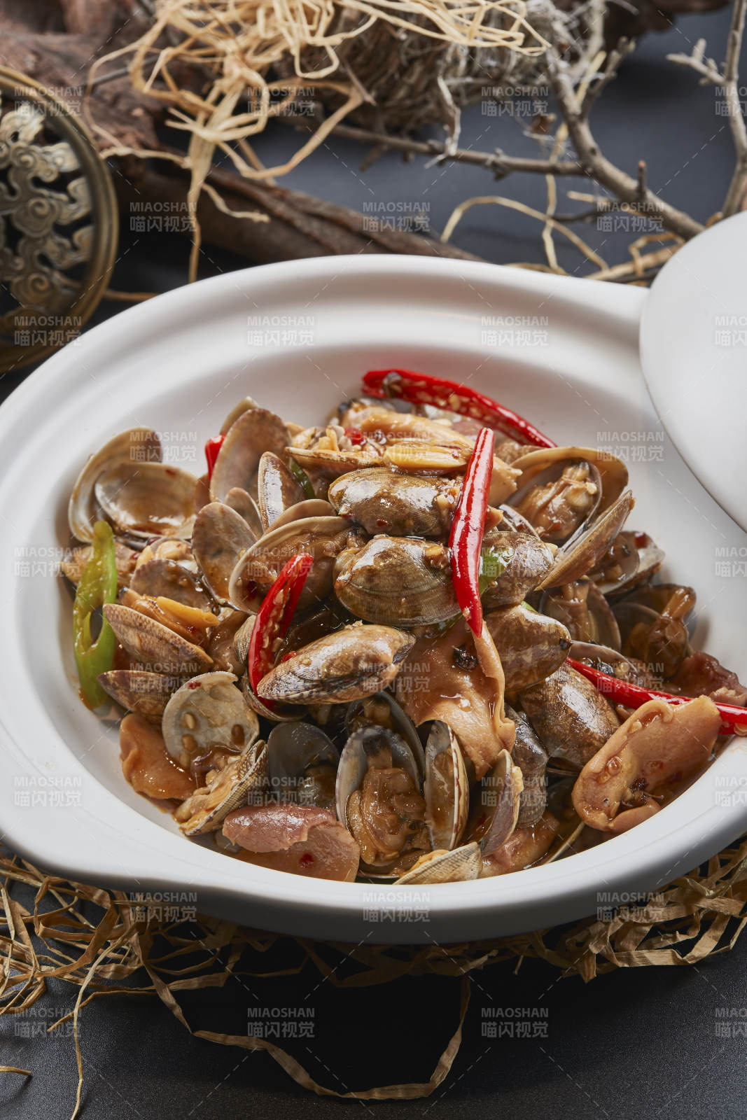 白色砂锅装的辣椒煲花蛤图片