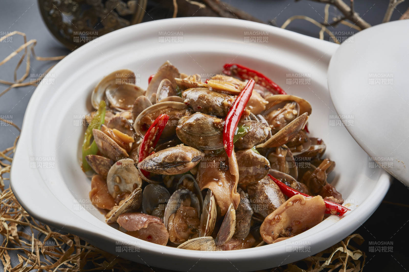 白色砂锅装的辣椒煲花蛤图片