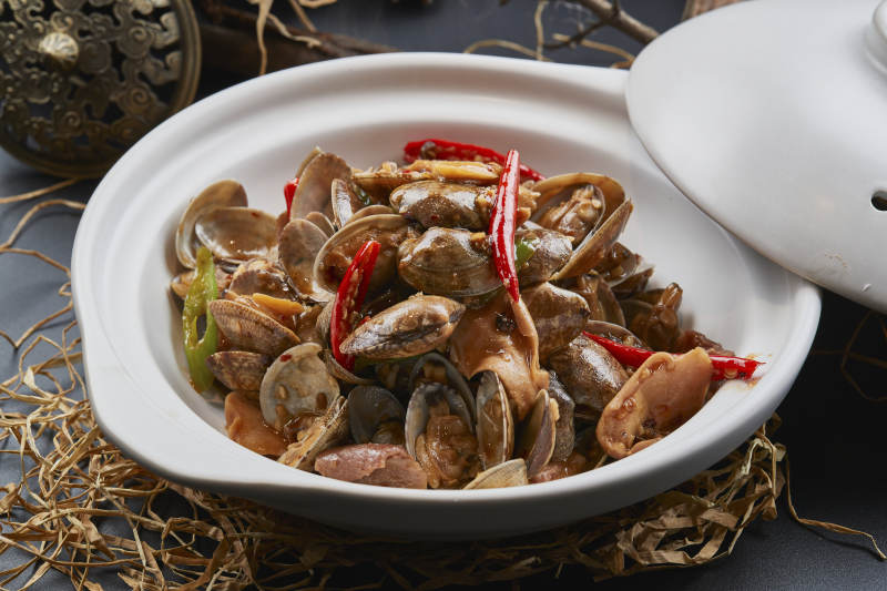 白色砂锅装的辣椒煲花蛤图片