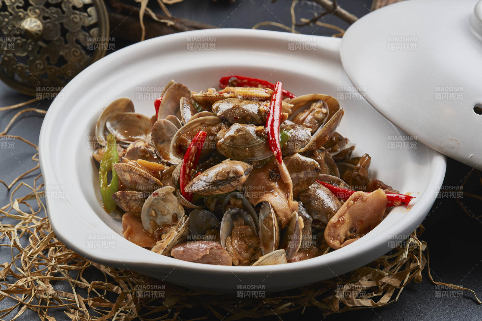 白色砂锅装的辣椒煲花蛤图片