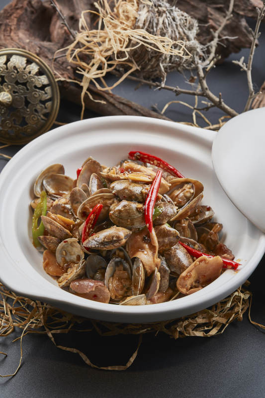 白色砂锅装的辣椒煲花蛤图片