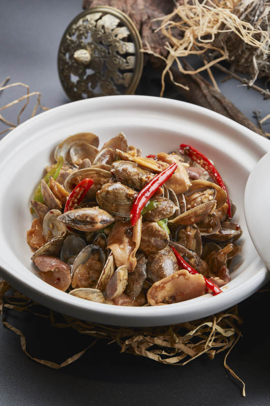 白色砂锅装的辣椒煲花蛤图片