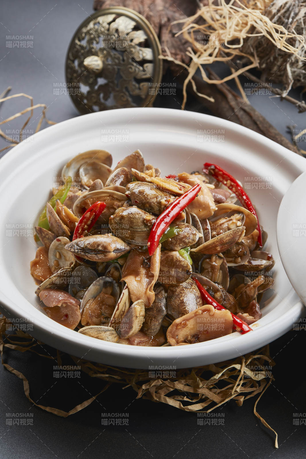 白色砂锅装的辣椒煲花蛤图片