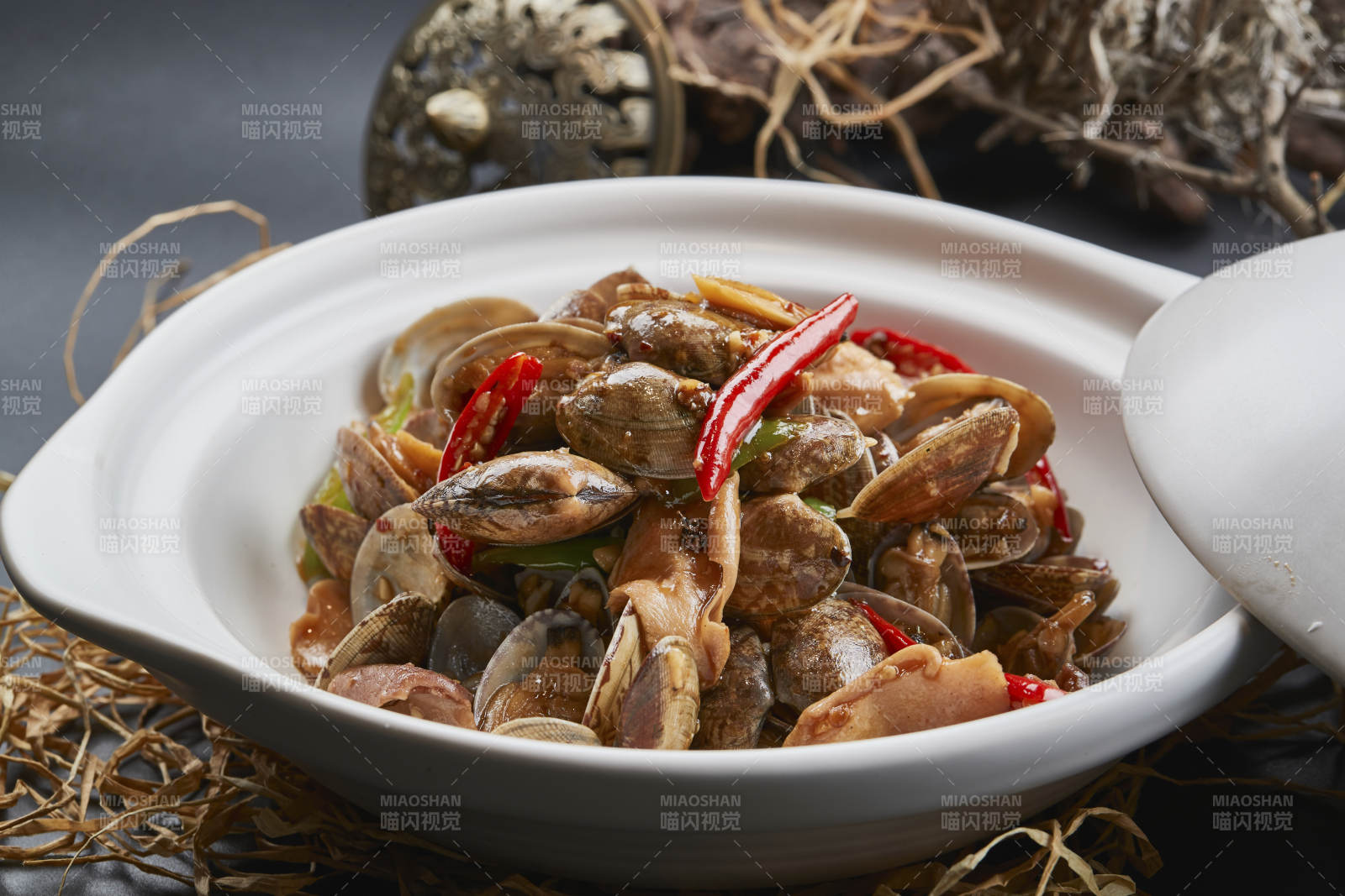 白色砂锅装的辣椒煲花蛤图片