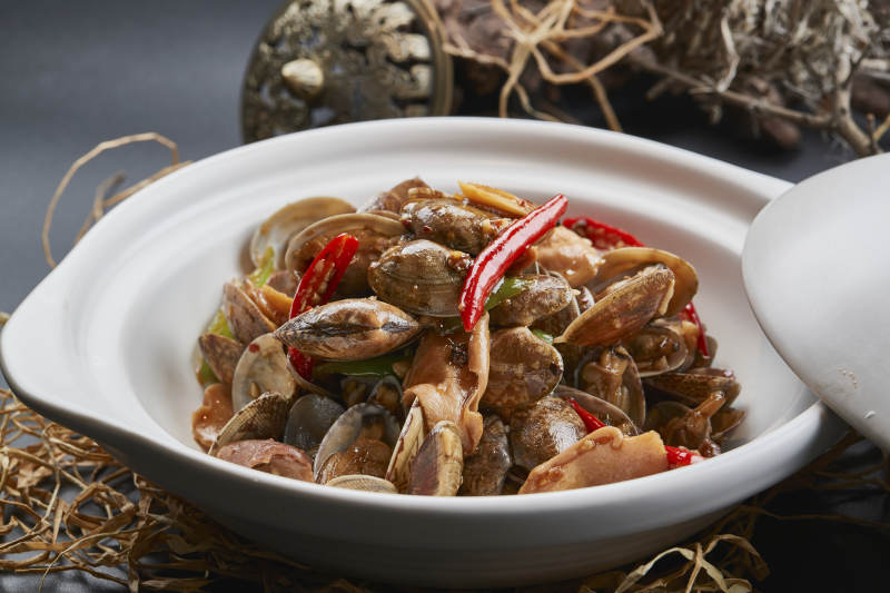 白色砂锅装的辣椒煲花蛤图片