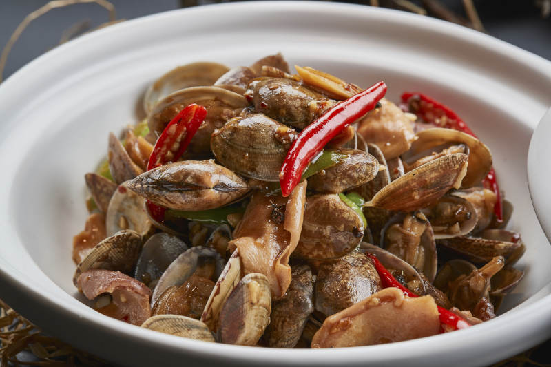 白色砂锅装的辣椒煲花蛤图片