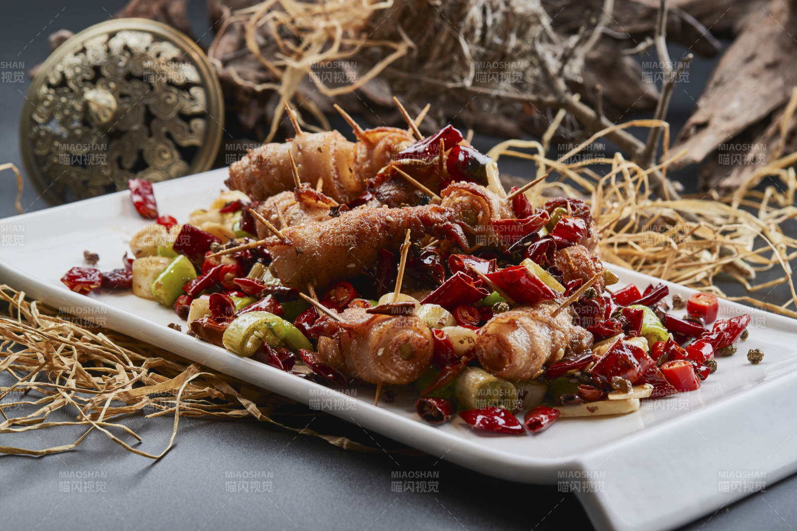 白瓷盘装的辣子油炸五花肉山椒卷图片