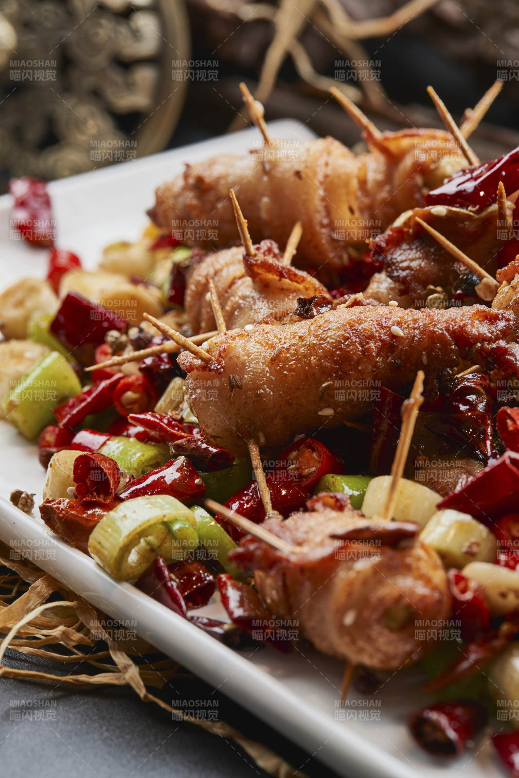 白瓷盘装的辣子油炸五花肉山椒卷图片