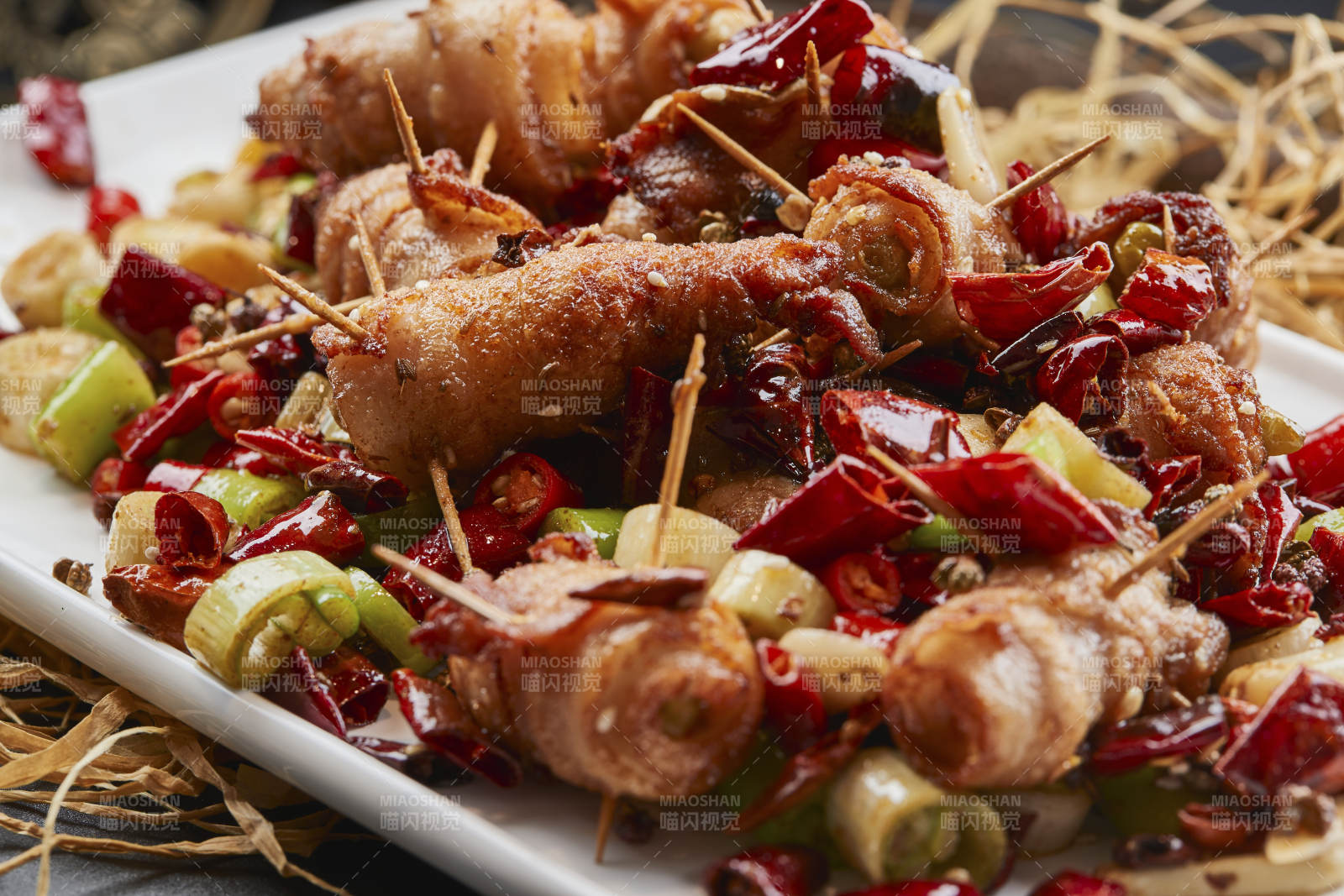 白瓷盘装的辣子油炸五花肉山椒卷图片