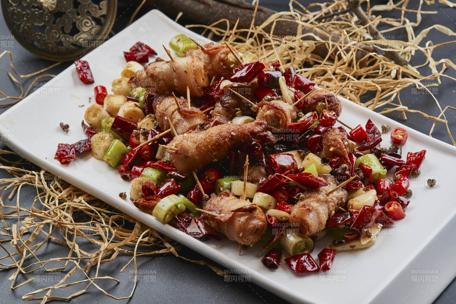 白瓷盘装的辣子油炸五花肉山椒卷图片