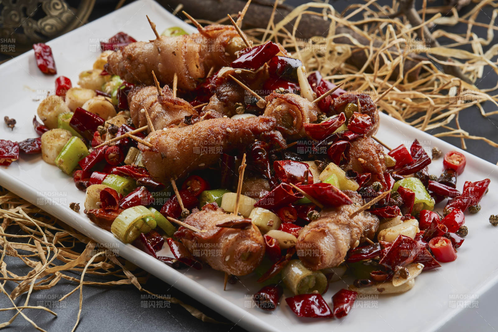 白瓷盘装的辣子油炸五花肉山椒卷图片